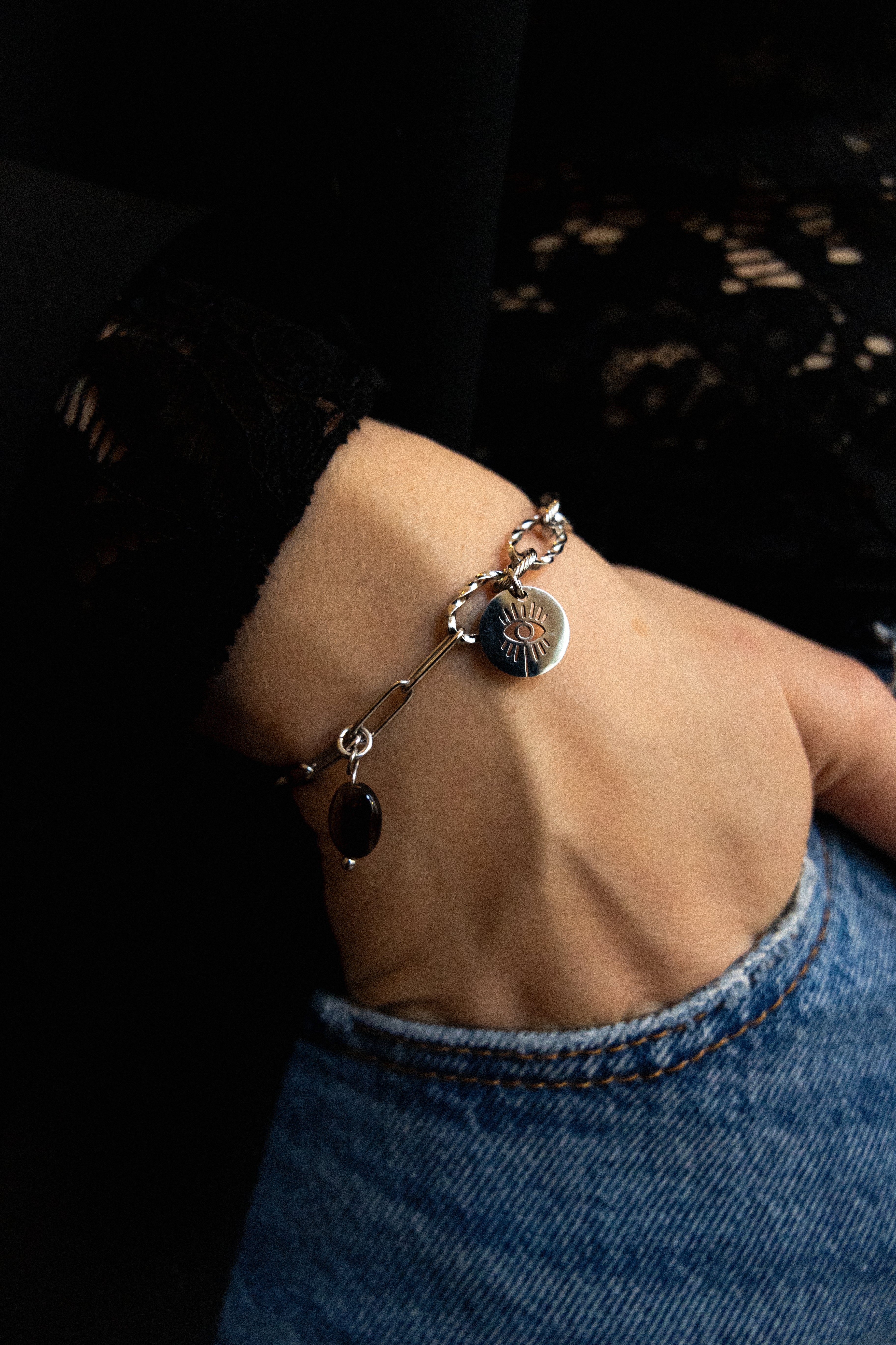 Bracelet Léna en acier inoxydable argenté et oeil de tigre avec un pendentif oeil protecteur.
