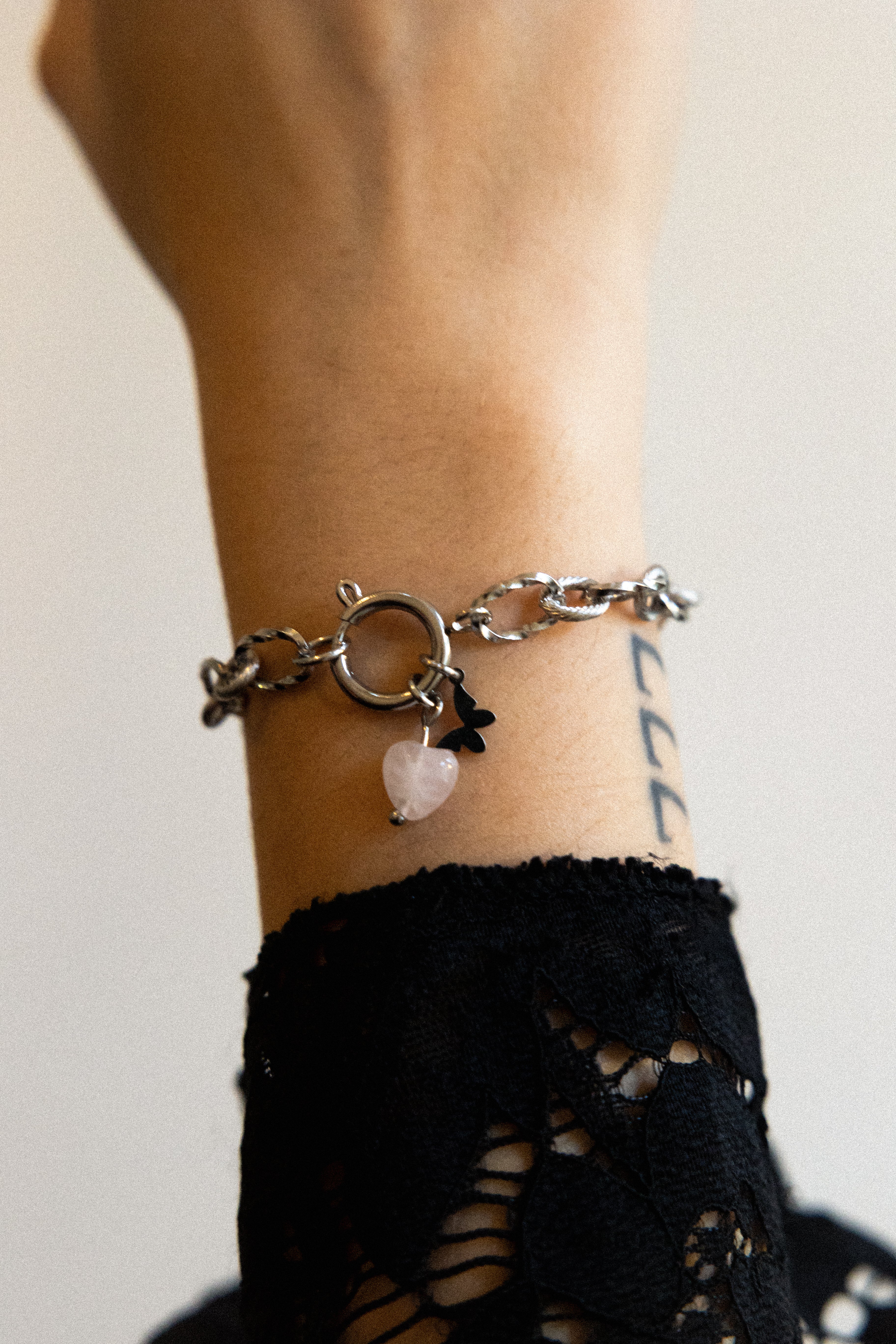 Bracelet Mallaury en acier inoxydable argenté et quartz rose avec un pendentif papillon