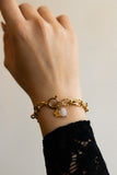 Bracelet Mallaury en acier inoxydable doré et quartz rose avec un pendentif papillon