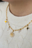 Collier Confiante en quartz rose, acier inoxydable doré, porté avec pendentif soleil, étoiles et cœurs