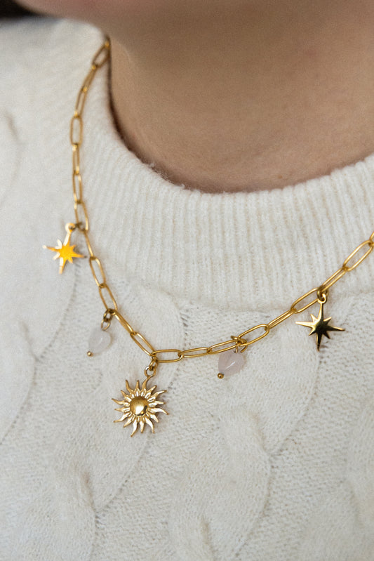 Collier Confiante en quartz rose, acier inoxydable doré, porté avec pendentif soleil, étoiles et cœurs